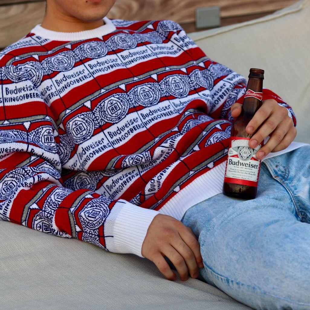 man wearing budweiser can repeat sweater and holding a budweiser bottle