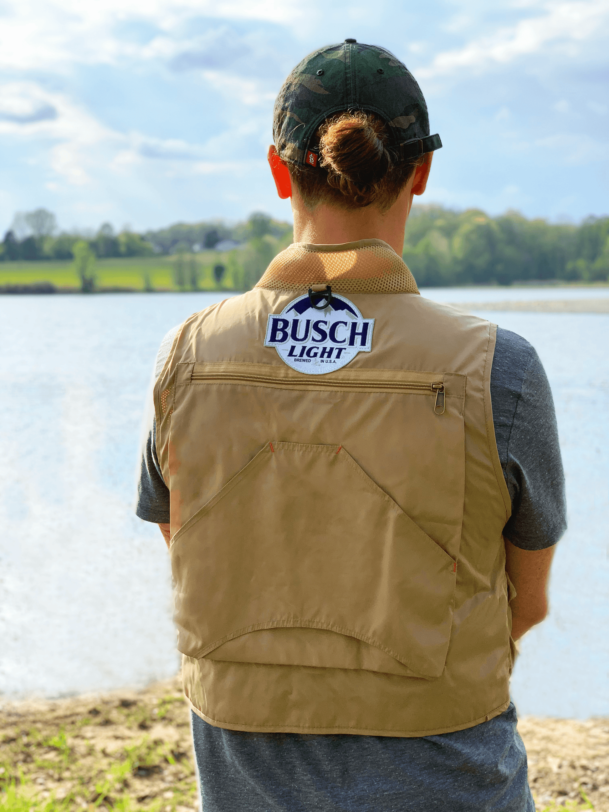 Man from the back wearing the Busch Light Fishing Vest by Lake