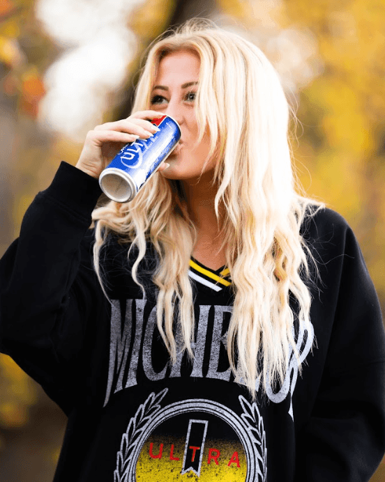 model drinking an ultra wearing the black crew neck 
