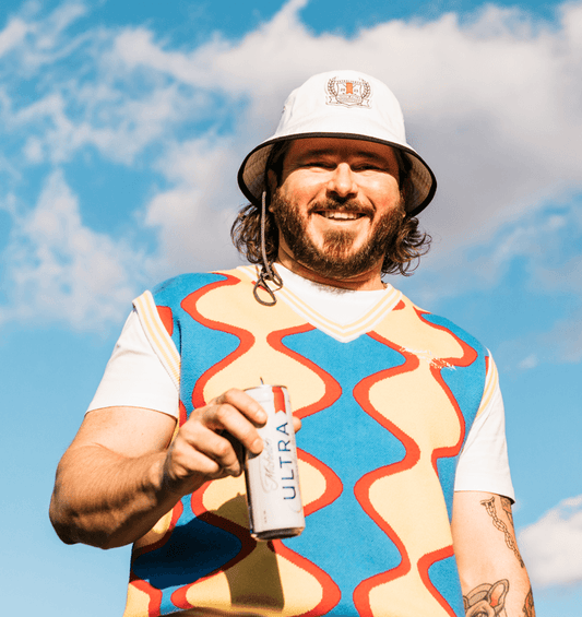 Lifestyle of Michelob ULTRA sweater vest with red, blue and yellow squiggle going down.