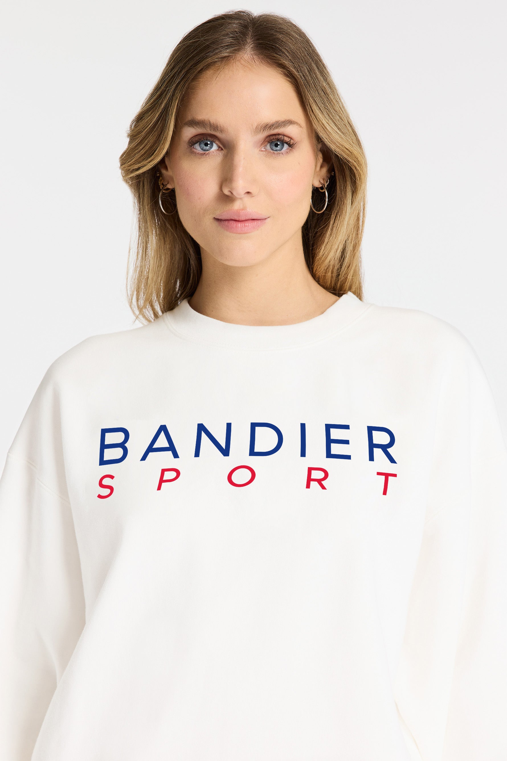 Model wearing Bandier x Michelob ULTRA Sweatshirt, front view with "BANDIER SPORT" in red and blue across center chest