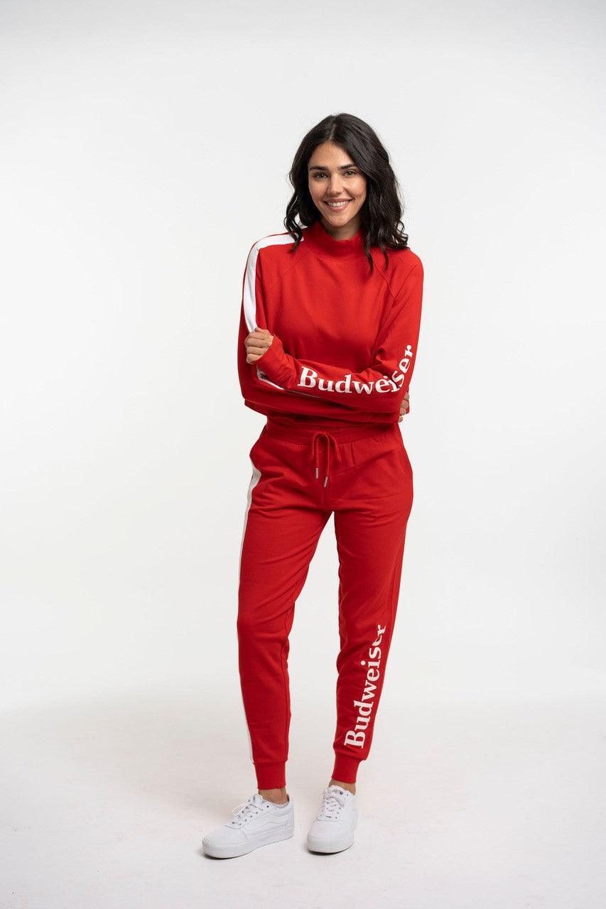 Model wearing red pullover with high neck with matching joggers