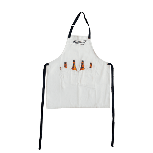 white Budweiser apron with two front pockets with screen printed bottles "inside" the pockets with necks sticking out. features the Budweiser bowtie logo on the front chest of apron.