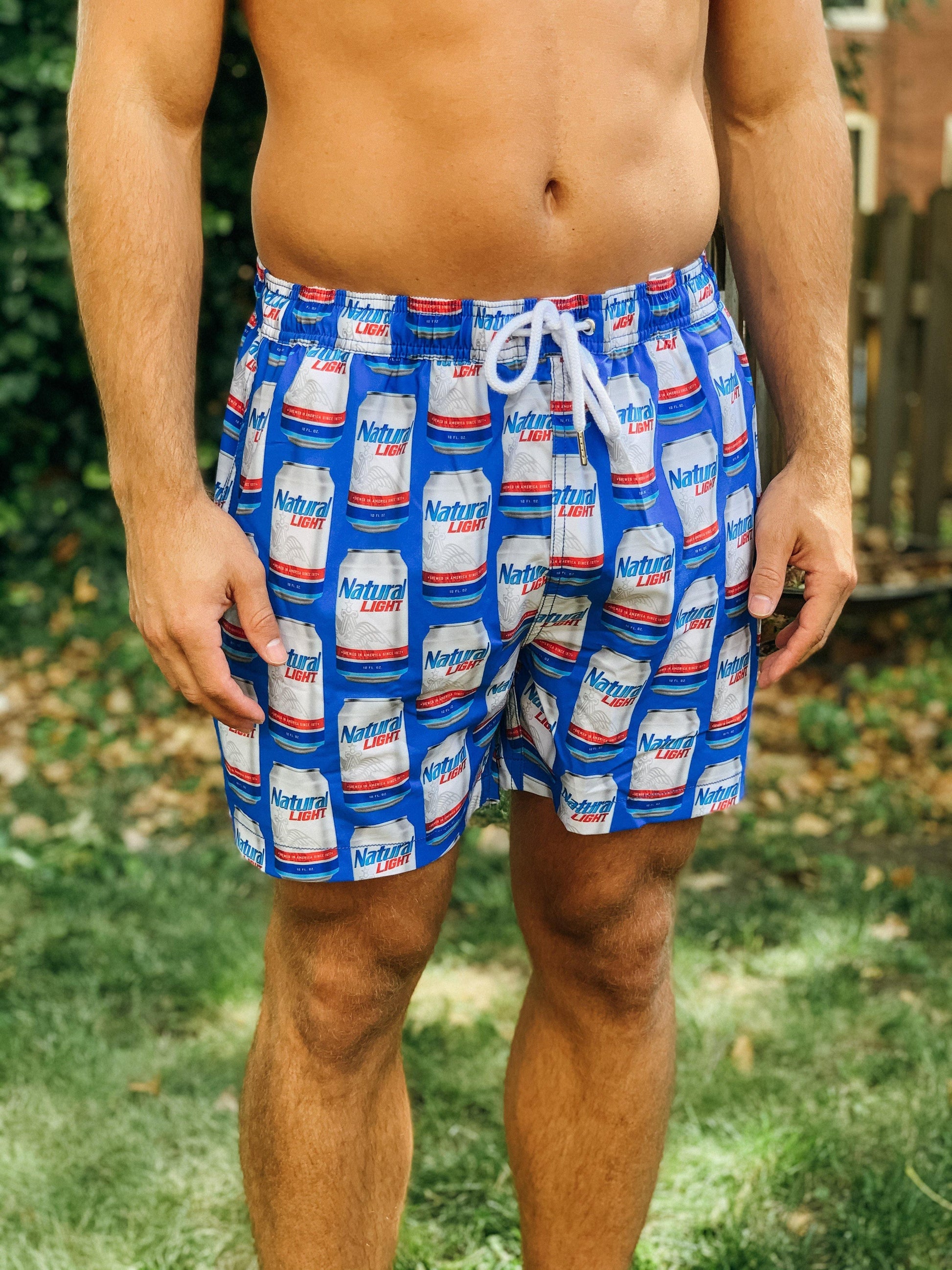 man wearing natural light scatter print beer can swim trunks