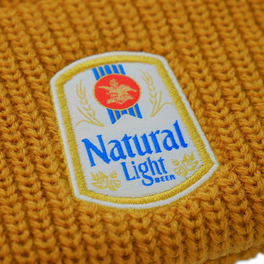 orange brown natural light beanie with vintage logo patch on front close up