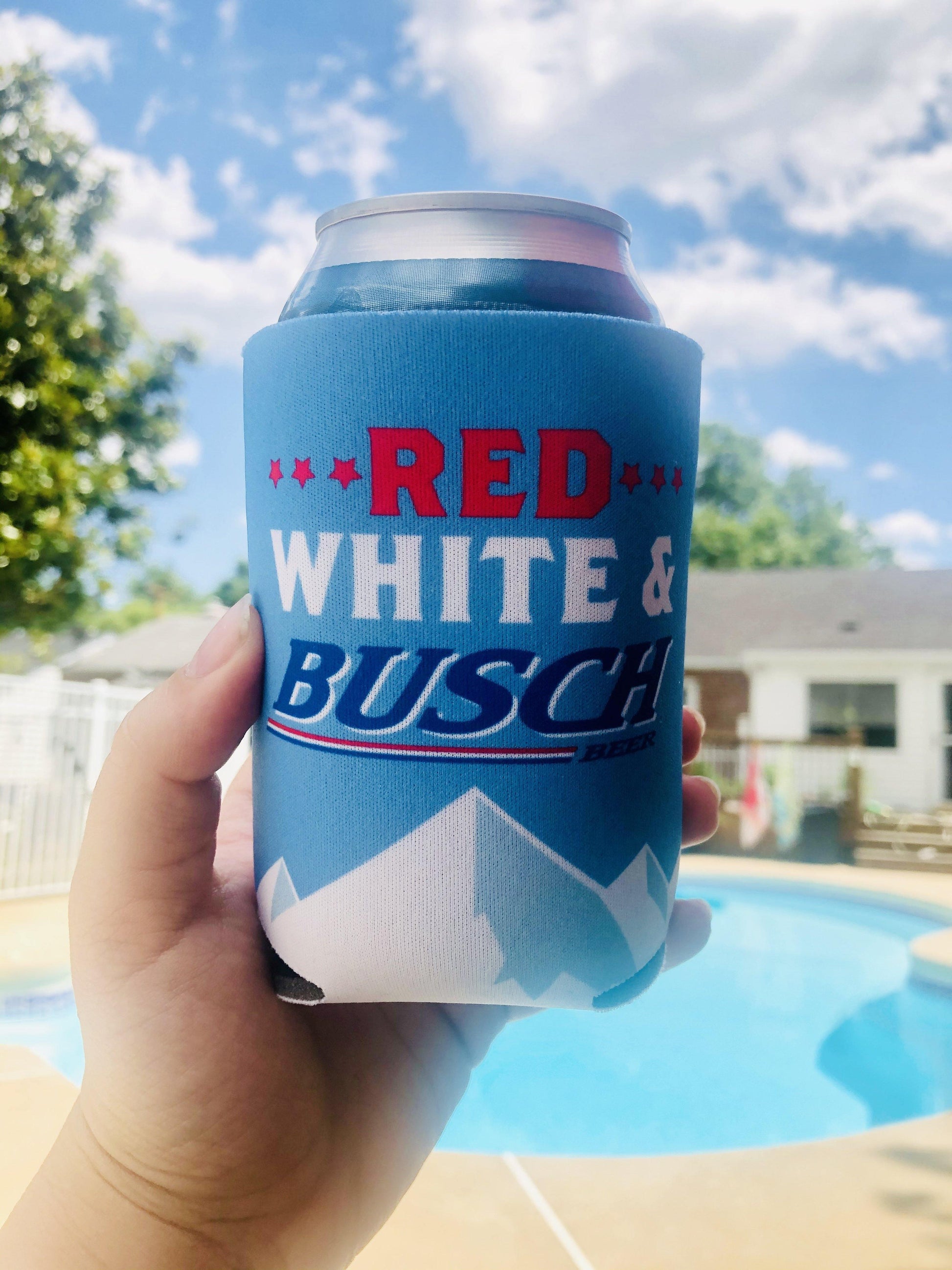 person holding beer can in red white and busch can coolie