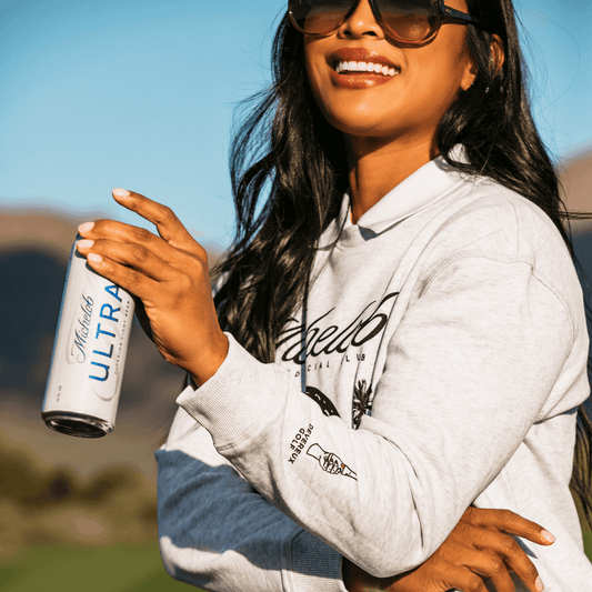 Lifestyle image of woman wearing grey Michelob Devereaux crewneck