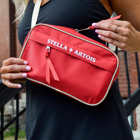 Lifestyle of red Stella Artois Fanny Pack with front zipper pocket and larger zipper pocket on top