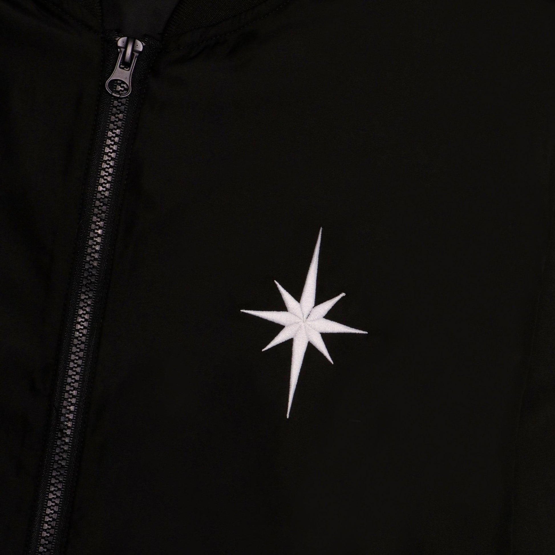 Close up of embroidered white star on front left chest