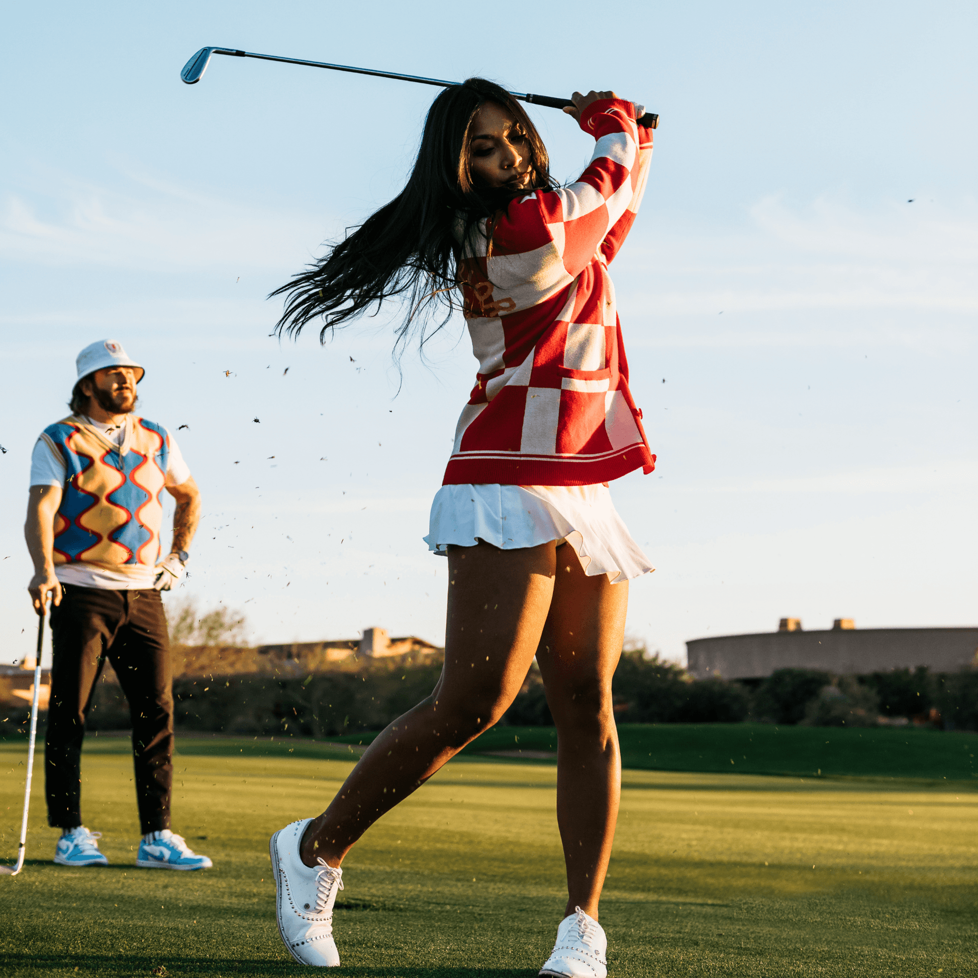 Lifestyle of woman wearing cardigan and swinging golf club